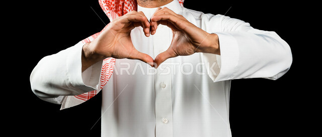 رجل عربي سعودي خليجي يشكل بيده شكل القلب، إيماءات يدين تدل على الحب والفرح والسعادة، أعياد ومناسبات، الشعور بالحب والغرام, مناسبات سعيدة, خلفية سوداء