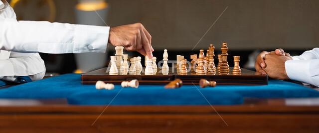 صورة مقربة لشابان عربيان سعوديان خليجيان يلعبان لعبة الشطرنج, مفهوم التركيز و التحدي, التخطيط والتفكير, لعبة رقمية استراتيجية على رقعة الشطرنج, أنشطه ترفيهيه, قضاء وقت ممتع, تسليه وترفيه