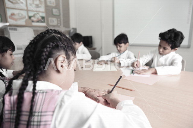 فصل مليء  بطلاب وطالبات عربيون سعوديون خليجيون يجلسون بأدب وانتظام في المدرسة الإبتدائية ,الاهتمام بالنشاطات الجماعية المدرسية , التربية والتعليم , المقررات والمناهج التعليمية الحديثة في المملكة العربية السعودية .