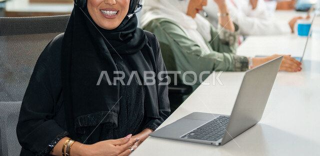  سيدة اعمال عربيه سعودية خليجية ترتدي العباءه تعمل في مقر الشركة ، تستخدم جهاز الحاسوب, انجاز مهام العمل، مركز خدمة العملاء, مهن و وظائف مكتبيه، إدارة الاعمال, شركة سعودية، بيئة عمل سعودي