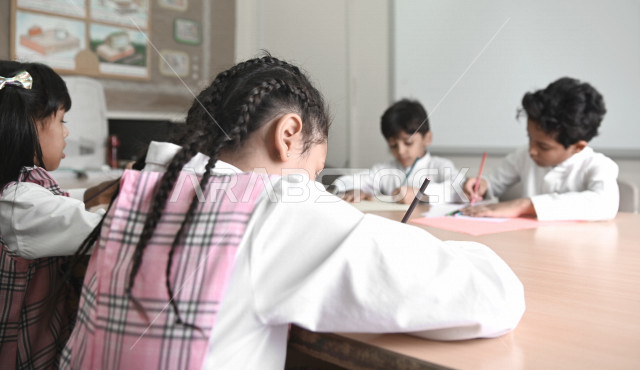 فصل مليء  بطلاب وطالبات عربيون سعوديون خليجيون يجلسون بأدب وانتظام في المدرسة الإبتدائية ,الاهتمام بالنشاطات الجماعية المدرسية , التربية والتعليم , المقررات والمناهج التعليمية الحديثة في المملكة العربية السعودية .