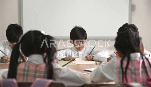 فصل مليء  بطلاب وطالبات عربيون سعوديون خليجيون يجلسون بأدب وانتظام في المدرسة الإبتدائية ,الاهتمام بالنشاطات الجماعية المدرسية , التربية والتعليم , المقررات والمناهج التعليمية الحديثة في المملكة العربية السعودية .