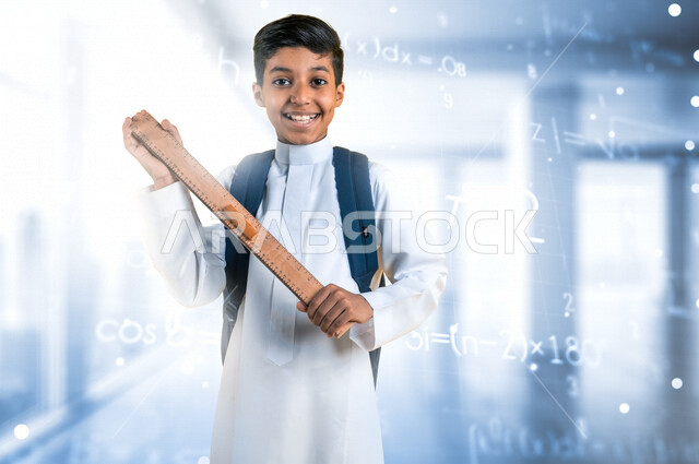 طالب عربي خليجي سعودي يمسك مسطرة مرقمة ويرتدي الزي المدرسي، حقيبة الظهر المدرسية، أدوات قرطاسية، الإستعداد للعام الدراسي الجديد، التعليم في السعودية، العودة إلى المدارس