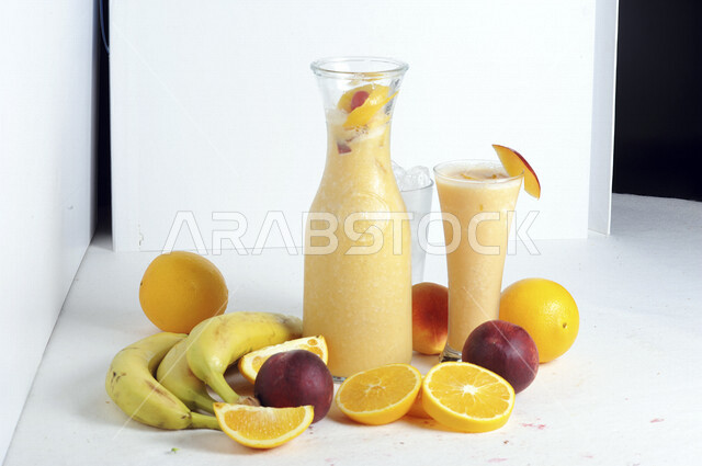 كوب من عصير الفواكه المشكل اللذيذ، مشروب بارد من الفواكه، مشروبات باردة، عصائر طبيعية لذيذة، عصير صحي ومفيد، كوكتيل صيفي منعش ومثلج، كوب زجاجي، خلفية بيضاء