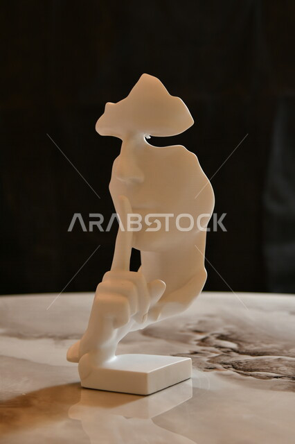 صورة لمجسم انسان يضع اصبع السبابة على فمه ، تمثال وجه تعبيري ، فن تشكيلي ، تماثيل و مجسمات ، ديكورات منحوتة