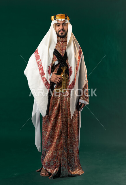 كروما، رجل عربي خليجي سعودي مبتسم، ينظر إلى الكاميرا، يرتدي الزي الخليجي السعودي، الإحتفال باليوم الوطني السعودي، هوية اليوم الوطني السعودي 92، صورة بالطول الكامل، خلفية خضراء، زي تراثي سعودي للمناسبات الوطنية، يوم التأسيس السعودي