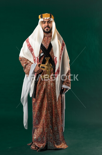 كروما، رجل عربي خليجي سعودي مبتسم، ينظر إلى الكاميرا، يرتدي الزي الخليجي السعودي، الإحتفال باليوم الوطني السعودي، هوية اليوم الوطني السعودي 92، صورة بالطول الكامل، خلفية خضراء، زي تراثي سعودي للمناسبات الوطنية، يوم التأسيس السعودي