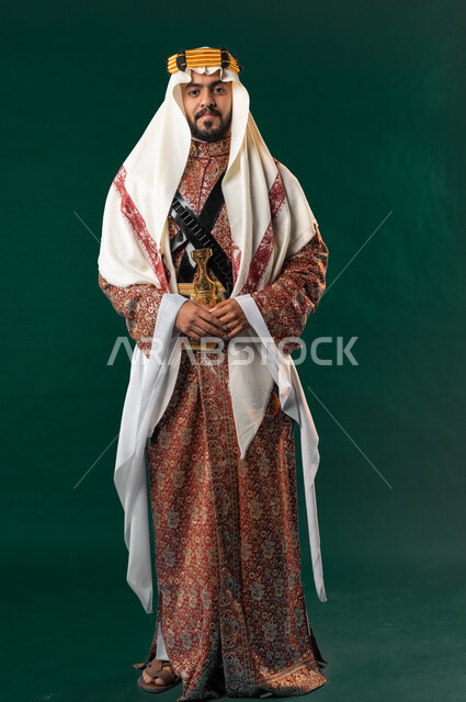 كروما، رجل عربي خليجي سعودي مبتسم، ينظر إلى الكاميرا، يرتدي الزي الخليجي السعودي، الإحتفال باليوم الوطني السعودي، هوية اليوم الوطني السعودي 92، صورة بالطول الكامل، خلفية خضراء، زي تراثي سعودي للمناسبات الوطنية، يوم التأسيس السعودي