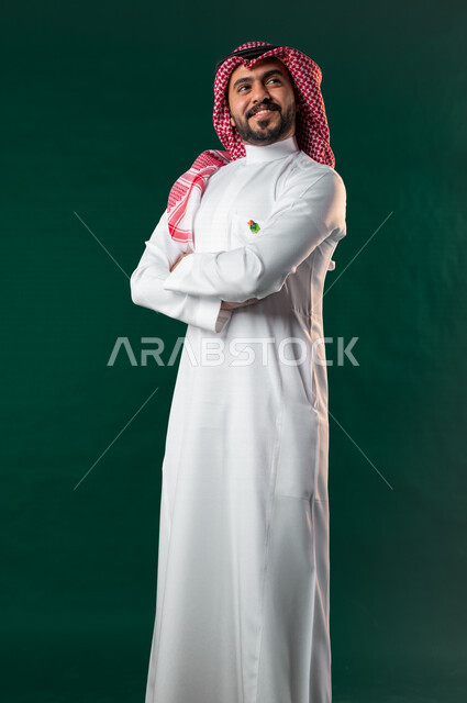 Karuma, Saudi Arabian Gulf man looking up with crossed hands, wearing traditional Saudi Arabian Gulf dress, Saudi National Day celebration, Saudi National Day 92 ID, green background, Saudi founding day, Saudi National Day