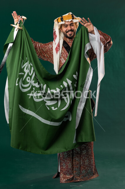 كروما لرجل عربي سعودي خليجي، يرتدي الزي الشعبي التقليدي العريق, دقلة أهل المنطقه الوسطى, يحمل السيف مع علم السعوديه, الإحتفال باليوم الوطني السعودي، هوية اليوم الوطني السعودي 92، أزياء سعودية تراثية، يوم التأسيس السعودي، العيد الوطني السعودي, خلفيه خضراء