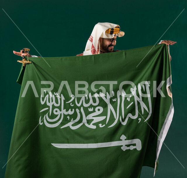 كروما لرجل عربي سعودي خليجي، يرتدي الزي الشعبي التقليدي العريق, دقلة أهل المنطقه الوسطى, يحمل السيف مع علم السعوديه, الإحتفال باليوم الوطني السعودي، هوية اليوم الوطني السعودي 92، أزياء سعودية تراثية، يوم التأسيس السعودي، العيد الوطني السعودي, خلفيه خضراء