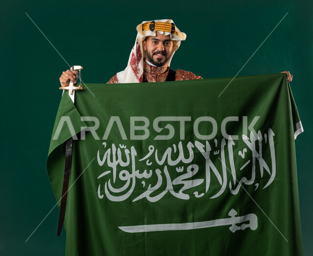 كروما لرجل عربي سعودي خليجي، يرتدي الزي الشعبي التقليدي العريق, دقلة أهل المنطقه الوسطى, يحمل السيف مع علم السعوديه, الإحتفال باليوم الوطني السعودي، هوية اليوم الوطني السعودي 92، أزياء سعودية تراثية، يوم التأسيس السعودي، العيد الوطني السعودي, خلفيه خضراء