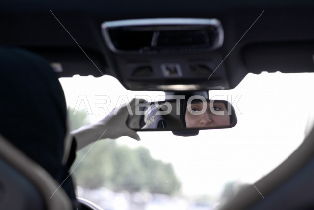 Ksa Car Rear View Reflection of the image of a young Saudi Arabian Gulf woman driver in ...