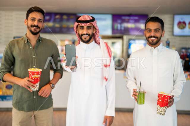 أصدقاء عرب سعوديون خليجيون في ردهة الإستقبال داخل السينما, إلتقاط صور تذكاريه، شراء المشروبات والفشار, الإستعداد للدخول الى صالة العرض، قضاء أوقات ممتعة مع الأصدقاء، مشاهدة الأفلام والعروض المسرحية، عطلة نهاية الأسبوع، سينما ومسرح، أنشطه ترفيهيه