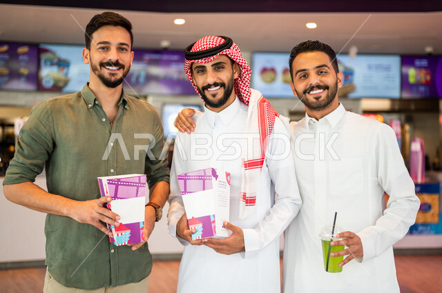 أصدقاء عرب سعوديون خليجيون في ردهة الإستقبال داخل السينما, النظر الى الكاميرا، شراء المشروبات والفشار, الإستعداد للدخول الى صالة العرض، قضاء أوقات ممتعة مع الأصدقاء، مشاهدة الأفلام والعروض المسرحية، عطلة نهاية الأسبوع، سينما ومسرح، أنشطه ترفيهيه