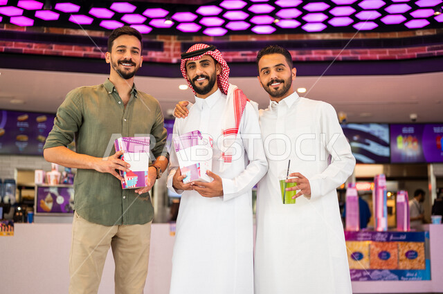أصدقاء عرب سعوديون خليجيون في ردهة الإستقبال داخل السينما, النظر الى الكاميرا، شراء المشروبات والفشار, الإستعداد للدخول الى صالة العرض، قضاء أوقات ممتعة مع الأصدقاء، مشاهدة الأفلام والعروض المسرحية، عطلة نهاية الأسبوع، سينما ومسرح، أنشطه ترفيهيه