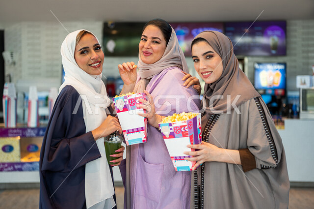 صديقات عربيات سعوديات خليجيات في ردهة الإستقبال داخل السينما, النظر الى الكاميرا، شراء المشروبات والفشار, الإستعداد للدخول الى صالة العرض، قضاء أوقات ممتعة مع الأصدقاء، مشاهدة الأفلام والعروض المسرحية، عطلة نهاية الأسبوع، سينما ومسرح، أنشطه ترفيهيه