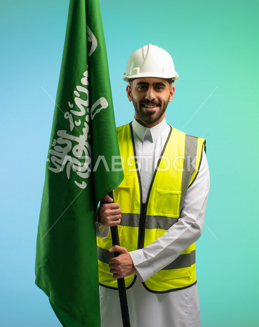 مهندس عربي خليجي سعودي يعمل في مجال الهندسة، يرتدي الخوذة وسترة الحماية، يحمل علم المملكة العربية السعودية، يحتفل باليوم الوطني السعودي، مهن ووظائف السعودية، العمالة السعودية، فرص عمل، مهنة الهندسة، اليوم الوطني السعودي، خلفية كروما