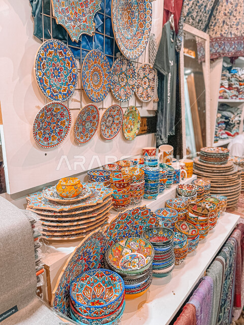 صورة مقربة لأطباق خزفية مزخرفة ملونة في احد الاسواق الشعبية، صحون مزخرفة، فنون جميلة لأواني مستديرة