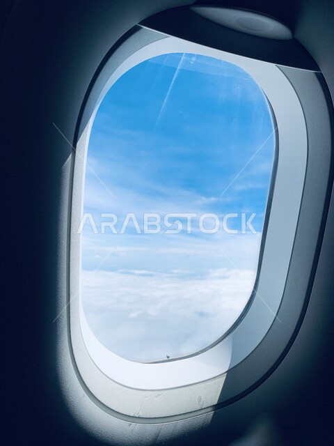 Close-up of a window of a plane, air transportation, airlines, a picture of inside the plane flying in the sky, a view of clouds in the sky