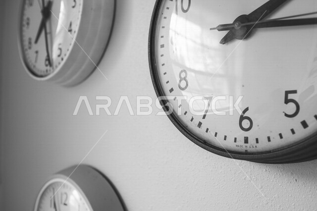 صورة مقربة لساعة حائط معلقة على الجدار، عقارب الساعة، معرفة الوقت، صورة بالابيض والاسود