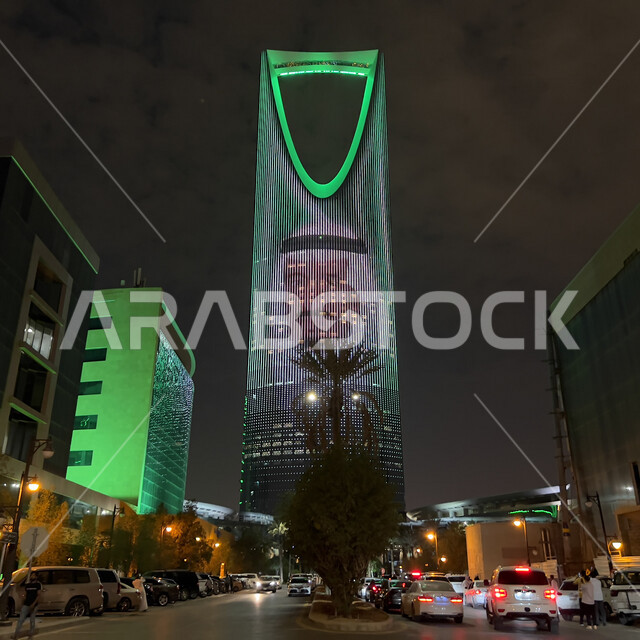 برج المملكة في الرياض بالمملكة العربية السعودية ليلا، برج المملكة مضيئ باللون الأخضر وعليه صورة الملك سلمان بن عبد العزيز ال سعود، إحتفالات اليوم الوطني السعودي 92، فعاليات اليوم الوطني السعودي 92، معالم الرياض، السياحة في السعودية