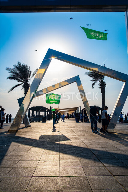 طائرات مروحية ترفع علم السعودية وتحلق في السماء فوق كورنيش جدة بالمملكة العربية السعودية، احتفالات اليوم الوطني السعودي92، عروض الطيران السعودي، فعاليات اليوم الوطني السعودي 92، يوم التأسيس 92، عيد الاستقلال السعودي 92، السياحة في السعودية 