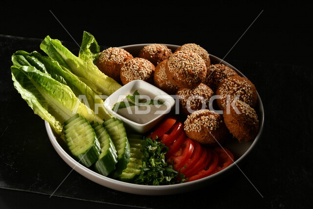 Close-up of a plate of falafel tablets with vegetables, Arabic restaurants, restaurants for oriental Arabic food, delicious meals, a delicious breakfast dish, falafel tablets, Arabic restaurants