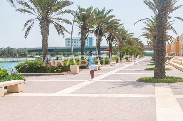 A Saudi Arabian Gulf man practicing morning sports on the Jeddah Corniche, running on the Jeddah Corniche Tourist Walk, Jeddah Waterfront, recreational tourist places in Saudi Arabia, recreation and entertainment, maintaining fitness and good health, recr