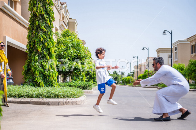 A Saudi Arabian Gulf family in high-end residential neighborhoods in Saudi Arabia, a residential compound in Saudi Arabia, residential villas, a residential complex, family housing in Saudi Arabia, a happy family atmosphere, the son is happy to play with 