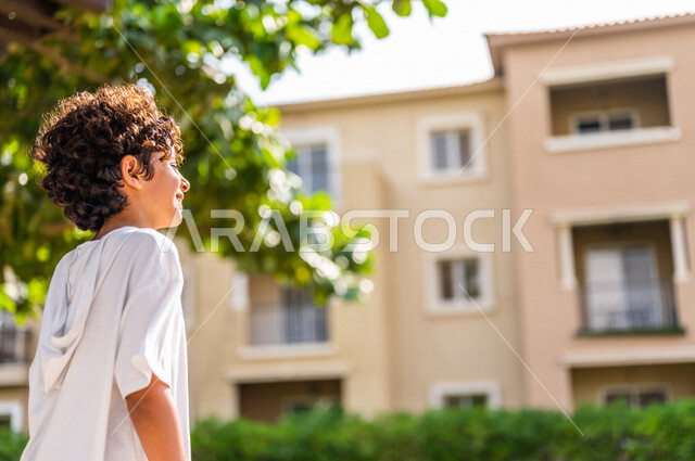 صورة مقربة لولد عربي خليجي سعودي، يتجول في الأحياء السكنية الراقية بالسعودية، كمباوند سكني بالمملكة العربية السعودية، مجمع سكني راقي بالسعودية، تصميم هندسي معماري حديث، فلل سكنية، الإسكان العائلي بالسعودية، جودة الحياة