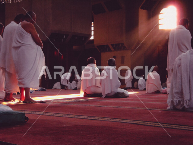 A group of Muslim pilgrims wearing the Ihram dress, performing prayer at the Sayeda Aisha Mosque in the Miqat al-Tana’im in Makkah, preparing to perform Hajj in Makkah al-Mukarramah, Saudi Arabia, Hajj season 2022, worshiping and getting closer to God