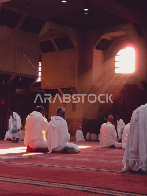 A group of Muslim pilgrims wearing the Ihram dress, performing prayer at the Sayeda Aisha Mosque in the Miqat al-Tana’im in Makkah, preparing to perform Hajj in Makkah al-Mukarramah, Saudi Arabia, Hajj season 2022, worshiping and getting closer to God