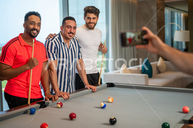  مجموعه من الشباب العرب السعوديون الخليجيون يرتدون ملابس كاجوال, إلتقاط صور تذكاريه جماعيه, لعبة البلياردو, أنشطه وهوايات شبابيه, متعه وترفيه, طاولة بلياردو( السنوكر), صاله رياضيه شبابيه, مقهى البلياردو, لاعبين محترفين, صالة البلياردو