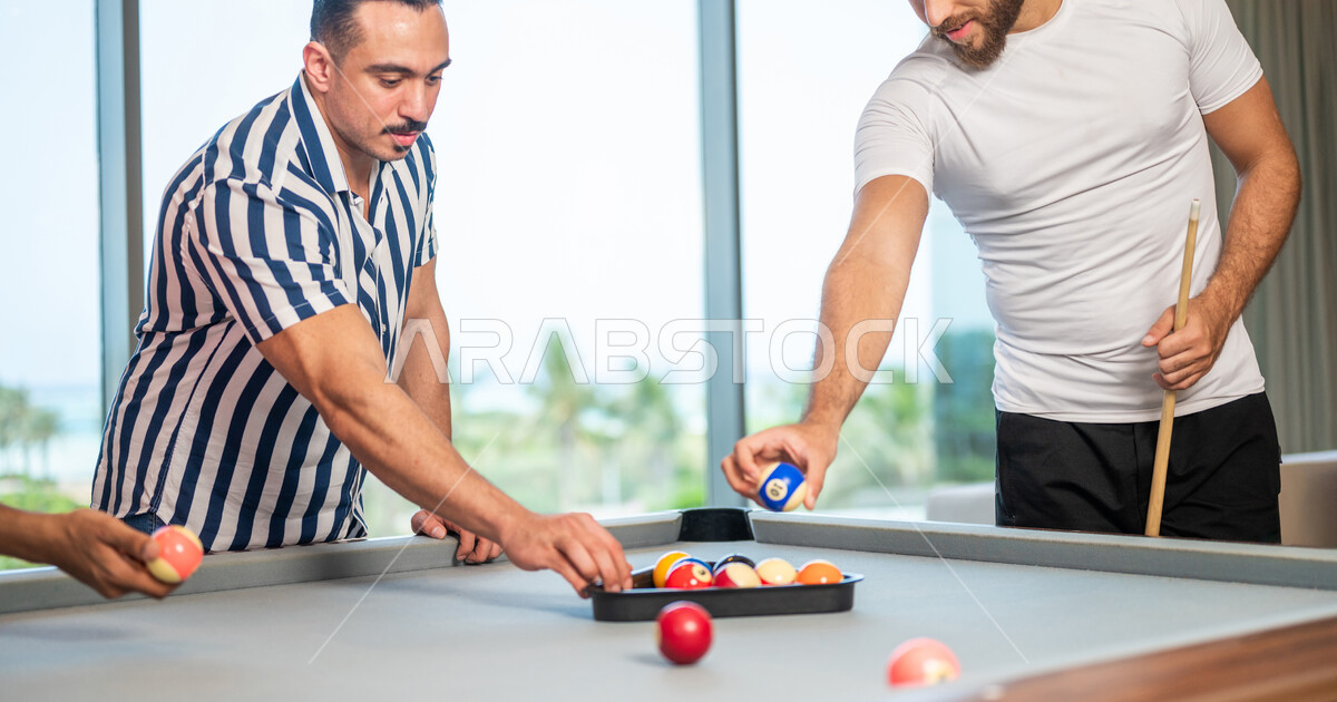 A group of Saudi Arabian Gulf youths wearing casual clothes, playing