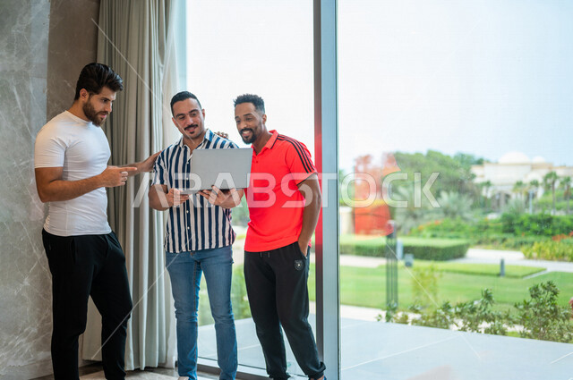  مجموعه من الشباب العرب السعوديون الخليجيون يرتدون ملابس كاجوال, مشاهدة برامج ترفيهيه من خلال جهاز الحاسوب المحمول, إجراء مكالمة فيديو, بث مباشر, علاقات اجتماعيه, انشطه ترفيهيه جماعيه, دردشة ومحادثات, زيارة الأصدقاء, التقاء الأصحاب, زيارة الأقارب