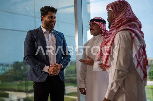فريق عمل سعودي ورجل بالبدلة الرسمية يقفون داخل مقر الشركة، دردشه ومحادثات, مهن ووظائف سعودية، شركة سعودية، بيئة عمل، زملاء عمل، الشراكة والتعاون، إجتماع عمل، مناقشة ومتابعة الأعمال, تحقيق استراتيجيات العمل, شركات عربيه سعوديه خليجيه