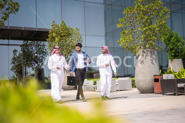Saudi Gulf Arab businessmen leaving the company building, public talks ...