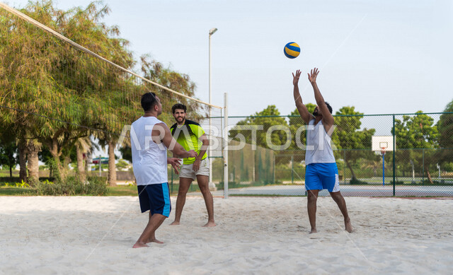 A team of Saudi Arabian Gulf friends playing volleyball, beach volleyball, recreational sports activities, beach volleyball in summer, youth activities and sports, competitions and challenges, physical activity