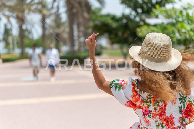 A Saudi Arabian Gulf woman practicing walking in the Jeddah Corniche promenade, a tourist beach, outdoor physical activity, hiking in Jeddah, the waterfront of Jeddah