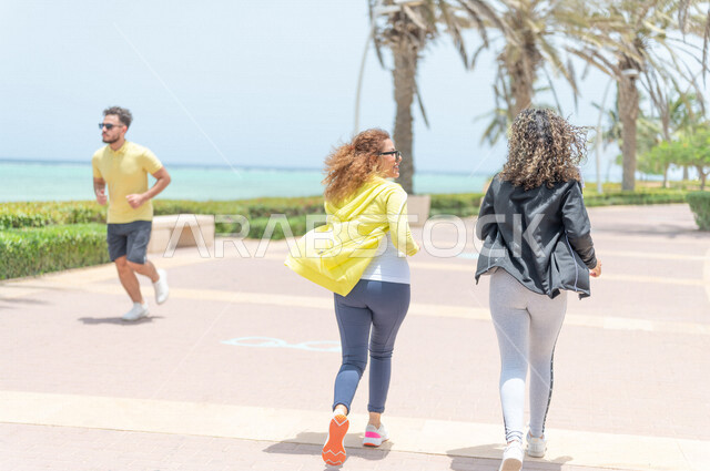 صديقتان عربيتان سعوديتان خليجيتان تمارسان رياضة المشي في ممشى كورنيش جده, شاطيء سياحي, نشاط بدني في الهواء الطلق, التنزه في جده, دردشة ومحادثات, الإستمتاع مع الأصدقاء, الواجهه البحريه لمدينة جده