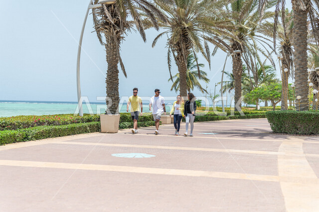 مجموعة من الأصدقاء العرب السعوديون الخليجيون يمارسون رياضة المشي, الصحه واللياقه الجسديه, ممارسة رياضة المشي في ممشى كورنيش جده, شاطيء سياحي, نشاط بدني في الهواء الطلق, التنزه في جده, رياضة الصباح, الواجهه البحريه لمدينة جده