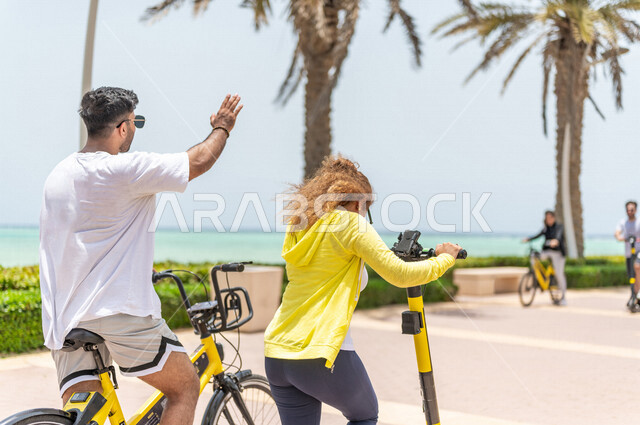 A Saudi Arabian Gulf man and woman riding an electric scooter in Jeddah ...