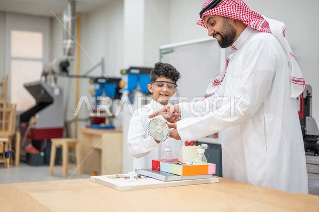 معلم عربي سعودي خليجي في بيئه مدرسيه تعليميه متطوره، متابعة مجموعة من الطلاب داخل مختبر مدرسي للإختراعات والأبحاث, نظام التعليم المنتسوري, التعليم الذكي، عالم جديد من التعليم, تعزيز العلوم والإبتكارات, تنمية المهارات ، المدارس المبتكره, جودة التعليم, مدار