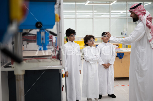 معلم عربي سعودي خليجي في بيئه مدرسيه تعليميه متطوره، متابعة مجموعة من الطلاب داخل مختبر مدرسي للإختراعات والأبحاث, نظام التعليم المنتسوري, التعليم الذكي، عالم جديد من التعليم, تعزيز العلوم والإبتكارات, تنمية المهارات ، المدارس المبتكره, جودة التعليم, مدار
