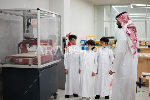 معلم عربي سعودي خليجي في بيئه مدرسيه تعليميه متطوره، متابعة مجموعة من الطلاب داخل مختبر مدرسي للإختراعات والأبحاث, نظام التعليم المنتسوري, التعليم الذكي، عالم جديد من التعليم, تعزيز العلوم والإبتكارات, تنمية المهارات ، المدارس المبتكره, جودة التعليم, مدار