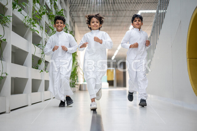 طلاب عرب سعوديون خليجيون يركضون في بهو المدرسه, وقت اللعب والترفيه, الفسحه المدرسيه, ايماءات تدل على السعاده والمرح, الإستعداد للفصل الدراسي الجديد, مدارس أكاديميه في المملكه العربيه السعوديه