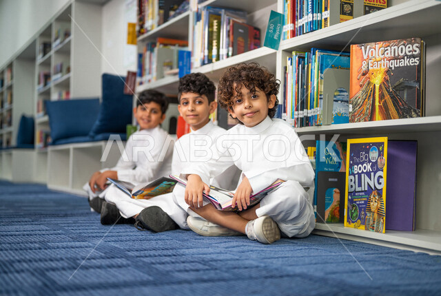 Saudi Arabian Gulf students sitting in the school library, enjoying reading books, the concept of self-education, school library, advanced educational school environment, innovative schools, quality education, academic schools in the Kingdom of Saudi Arab