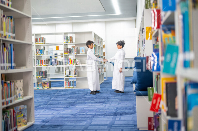 طالبان عربيان سعوديان خليجيان يتقابلان في المكتبة المدرسية، التحيه والسلام, لقاء الأصدقاء في مكتبة المدرسة، بيئه مدرسيه تعليميه متطوره, المدارس المبتكره, مدارس أكاديميه في المملكة العربية السعودية