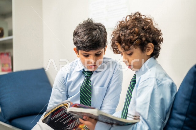 طالبان عربيان سعوديان خليجيان يقومان بقراءة كتاب، مكتبه مدرسيه, الإستعداد للإمتحانات المدرسيه, الدراسه والمذاكره, مفهوم المذاكرة الجماعيه, التعليم والثقافه، التعليم الذاتي, بيئه مدرسيه تعليميه متطوره, مدارس أكاديميه في المملكة العربية السعودية